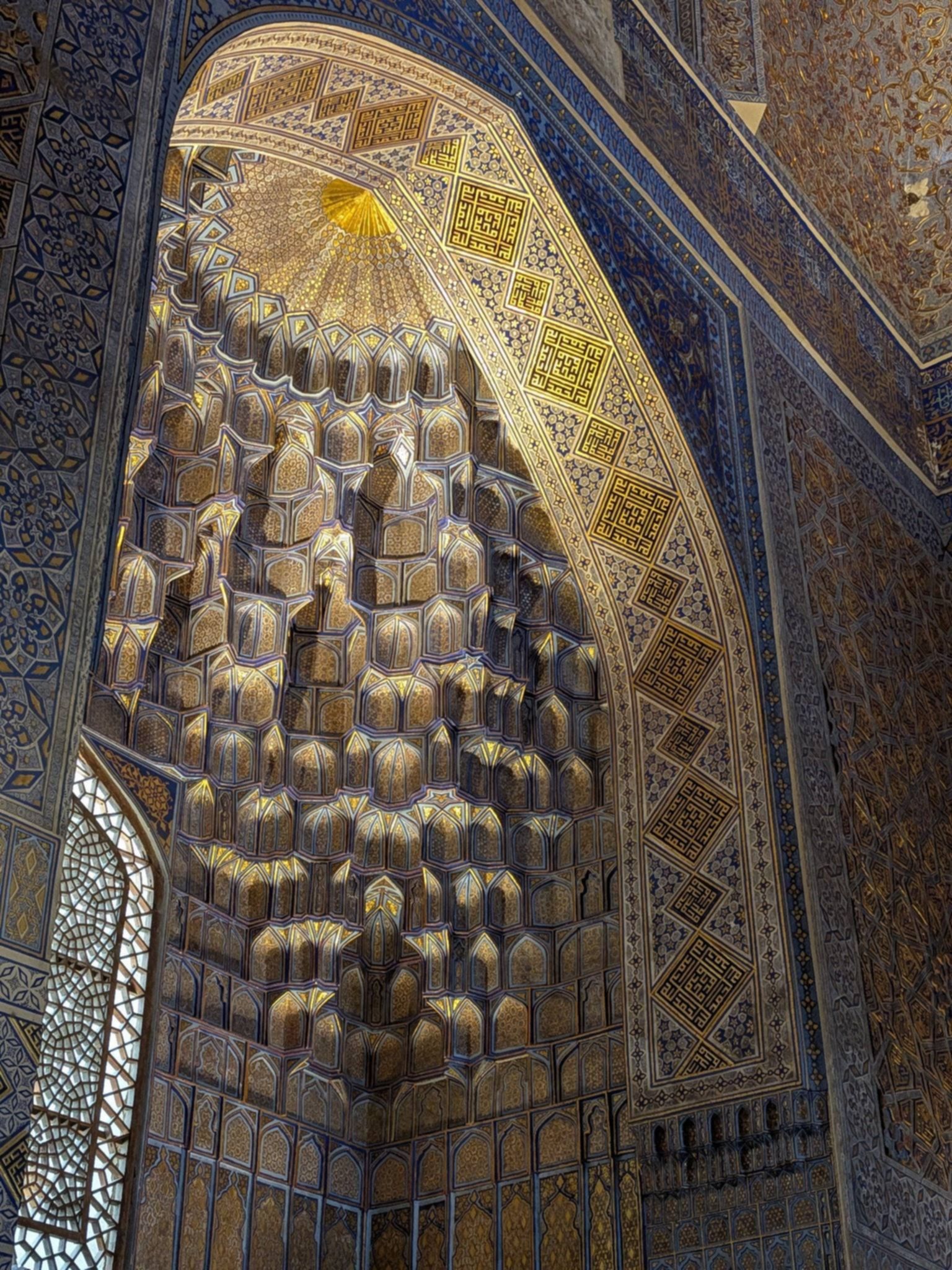 Bogato zdobione złotem i niebieskimi ornamentami sklepienie oraz dekoracje wnętrza mauzoleum Gur-e Amir w Samarkandzie.